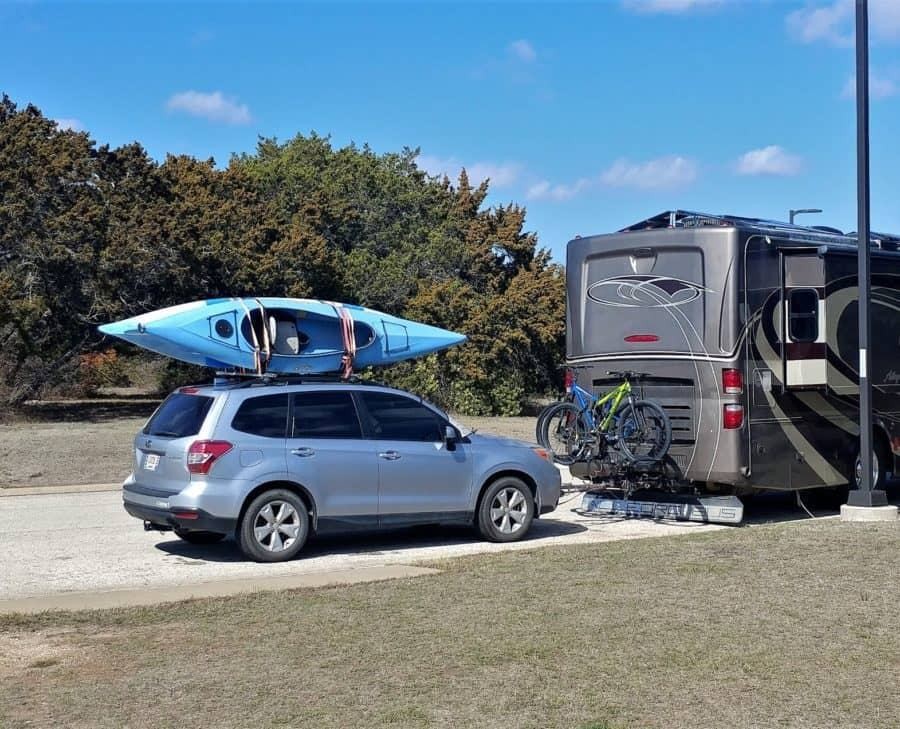 Bikes positioned on the rack between the RV and tow car, illustrating efficient space utilization.