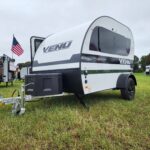 Front view of the Encore RV VENŪ 1500 lb travel trailer highlighting its modern design and compact profile.