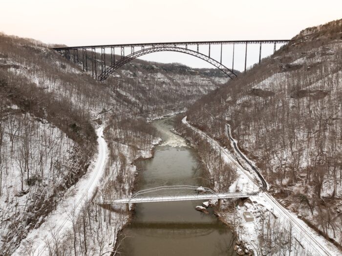 The iconic New River Gorge Bridge in winter, surrounded by snow