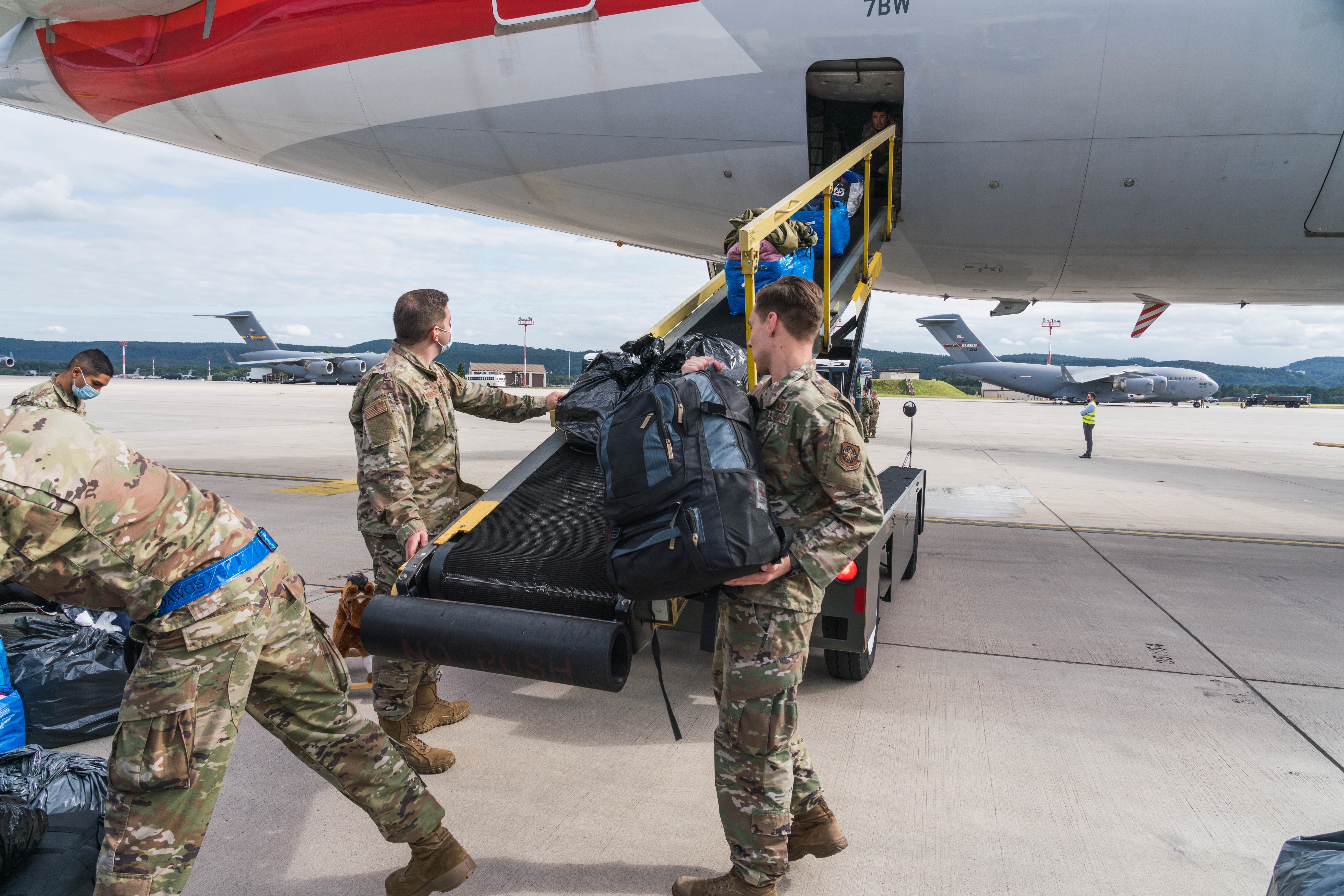 U.S. Air Force personnel load luggage onto an American Airlines plane at Ramstein Air Base during Operation Allies Refuge, showcasing the role of Civil Reserve Air Fleet Aircraft in passenger movement.