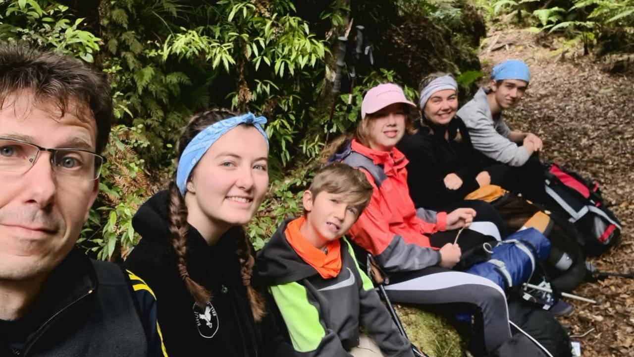 Family backpacking in a lush New Zealand landscape