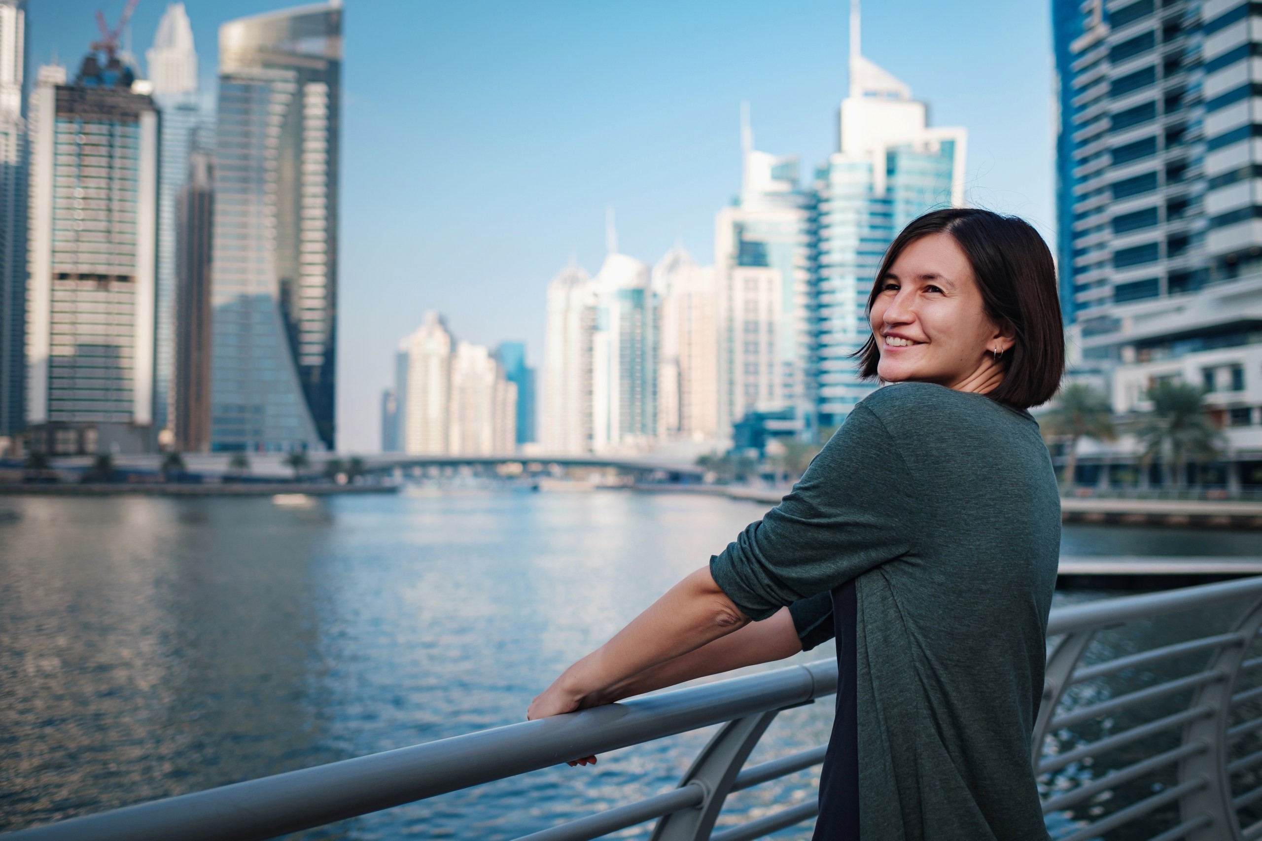 Visitor enjoying the scenic Dubai Marina, illustrating the city's modern attractions and the importance of respecting local dress codes for a safe and culturally aware travel experience.