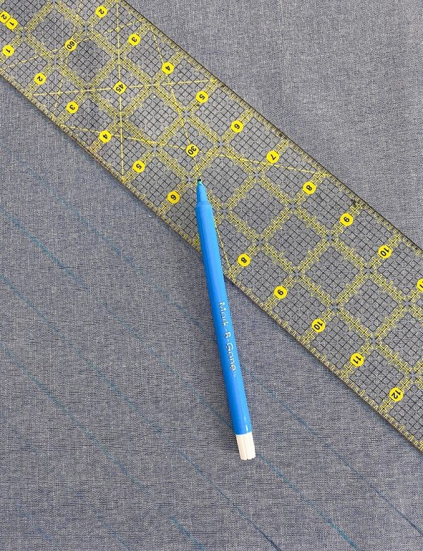 Marking diagonal lines on the fabric backing with a water-soluble pen and ruler.