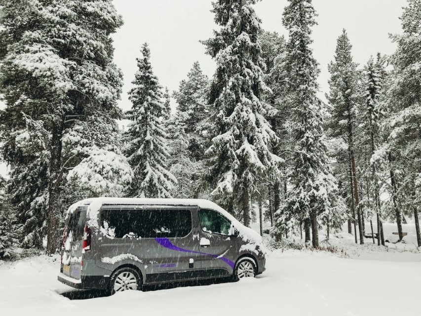 A camper van parked in the forests during a big snow storm