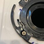 Cracked plastic toilet flange in a travel trailer, highlighting a common cause of black water leaks and odor issues related to the travel trailer toilet seal.