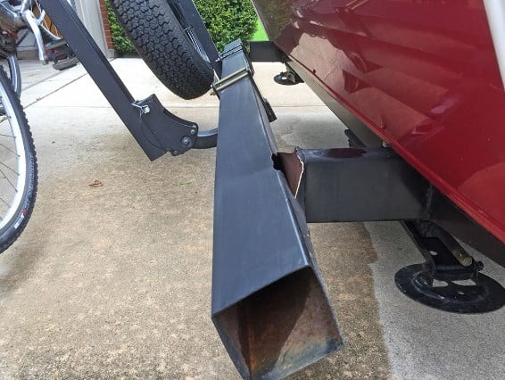 Bike rack improperly attached to a trailer bumper, illustrating a dangerous and unstable setup.