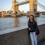 Alysha standing near Tower Bridge in London, smiling and enjoying the view