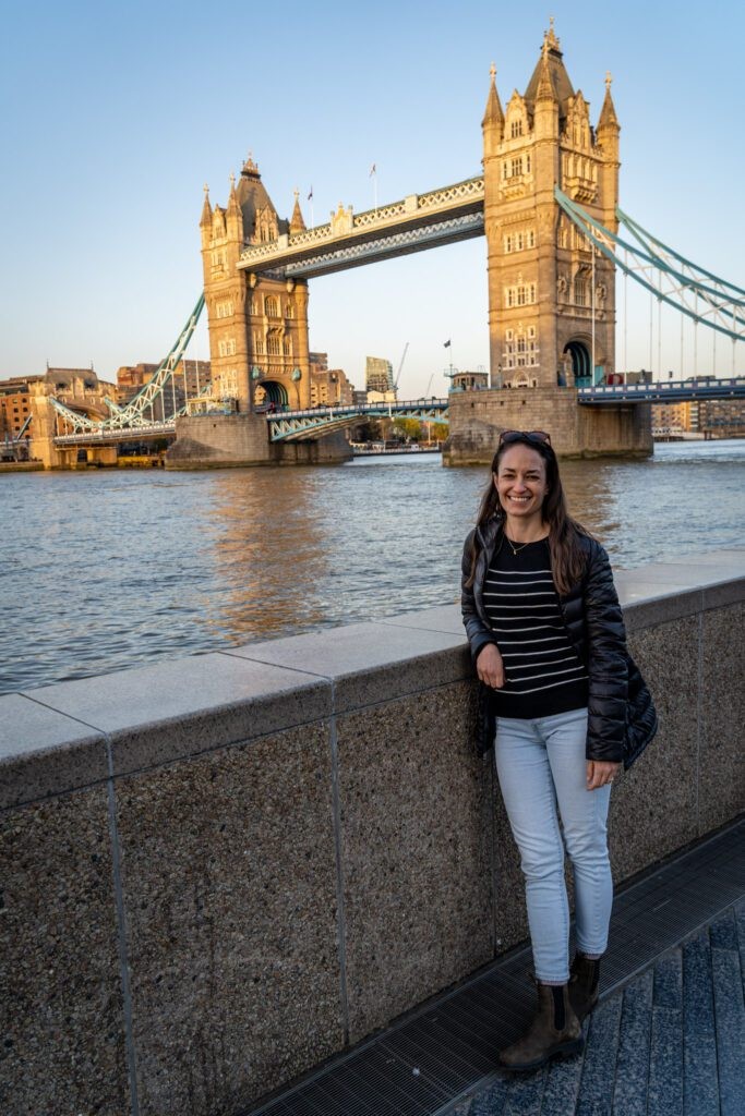 Alysha standing near Tower Bridge in London, smiling and enjoying the view