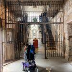 a person in a wheelchair explores an old prison