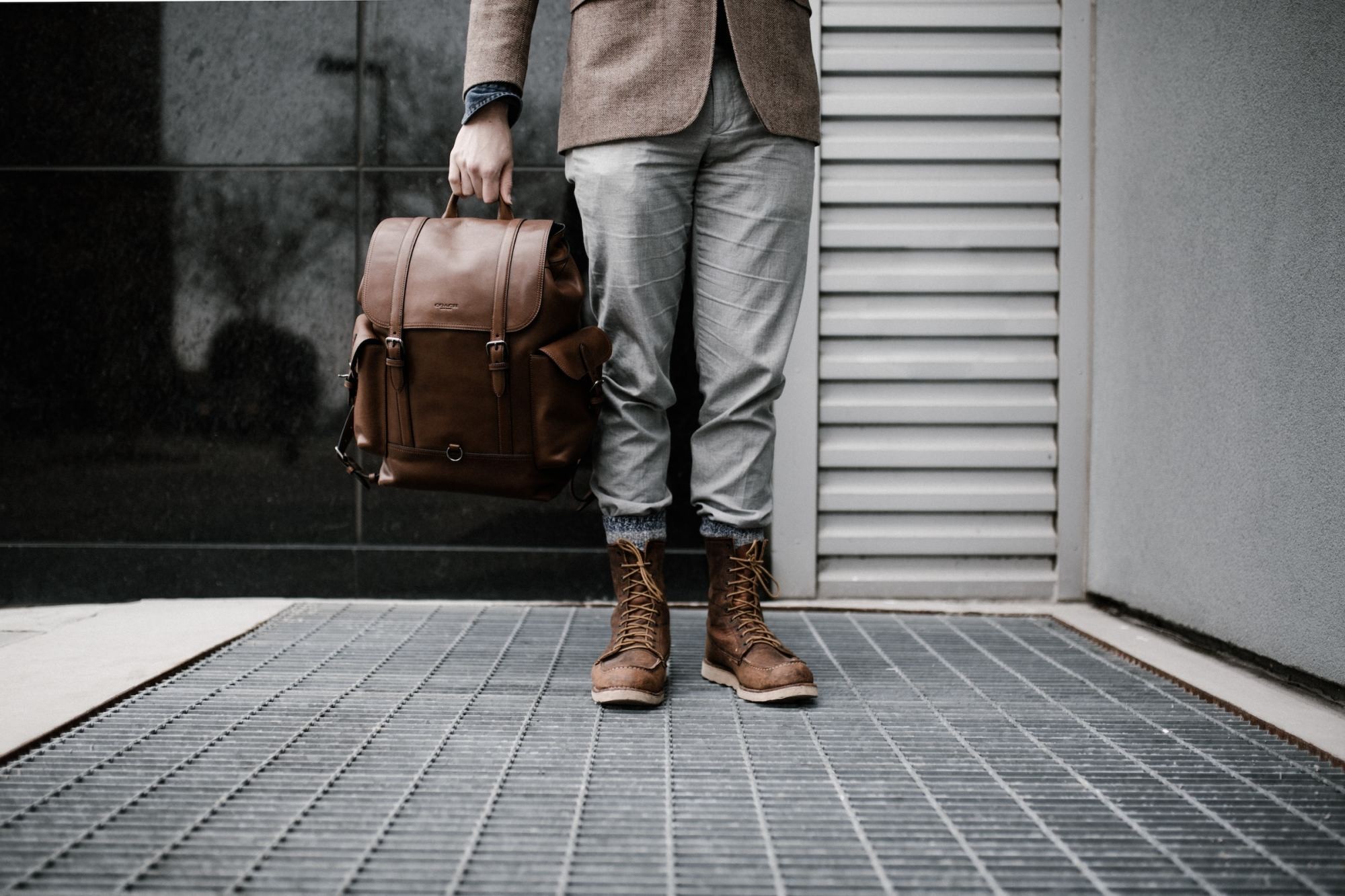 A businessman in stylish attire stands confidently on a city street, symbolizing the professional aspect of corporate travel.