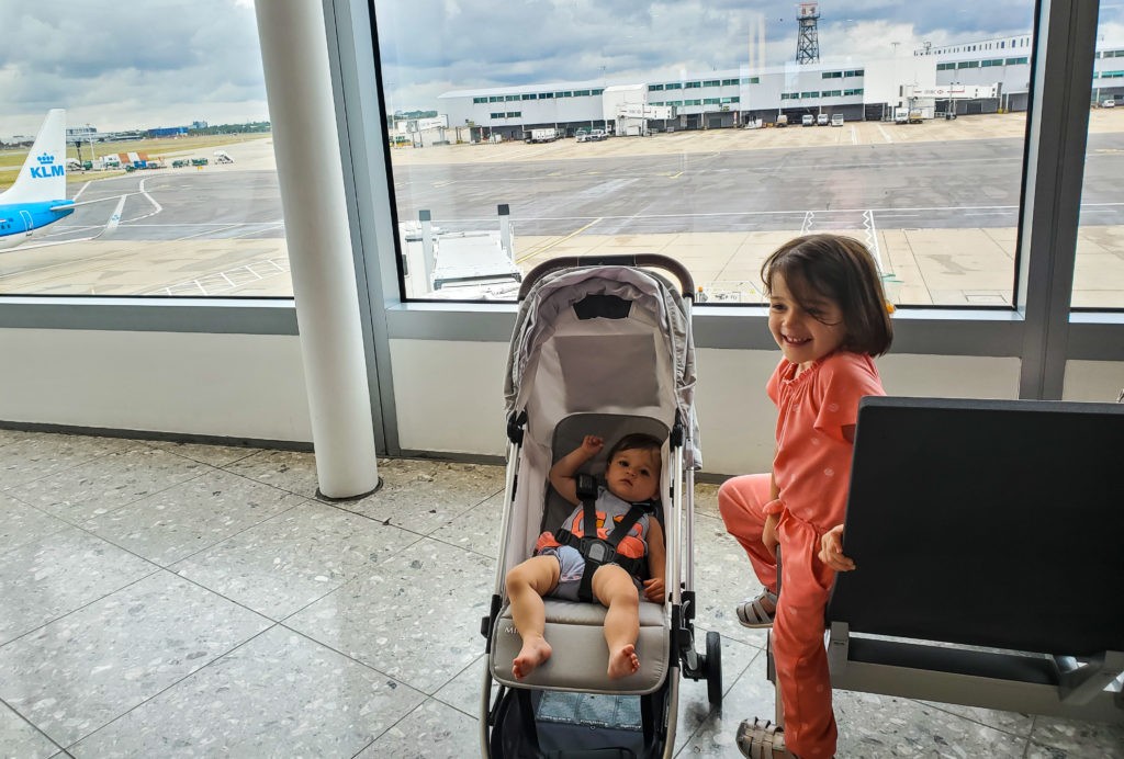 baby in uppababy minu stroller and toddler in an airport