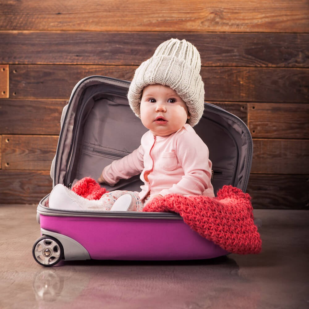 Cute baby in pink travel bag