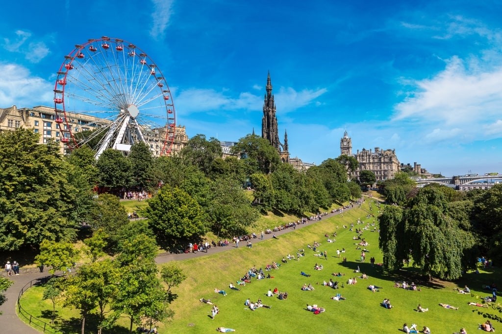 A vibrant park scene in Edinburgh during springtime, filled with blooming flowers and lush greenery