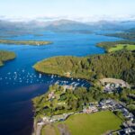 Loch Lomond in the summer, showcasing its tranquil waters and lush green surroundings