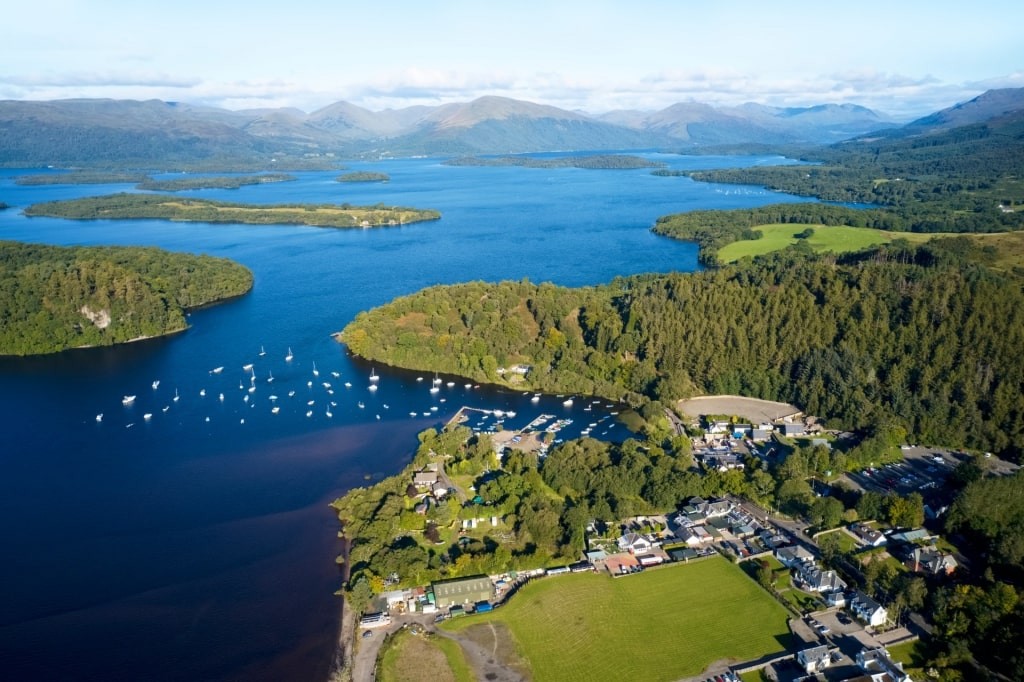 Loch Lomond in the summer, showcasing its tranquil waters and lush green surroundings