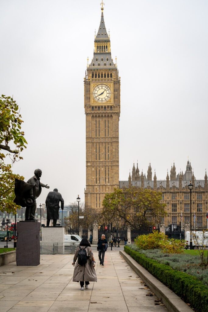 Big Ben and the Houses of Parliament towering over Westminster Bridge in London, under a clear sky