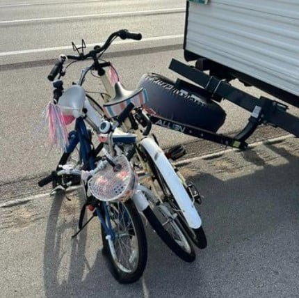 Warning against trailer bumper bike rack attachments due to potential failure.