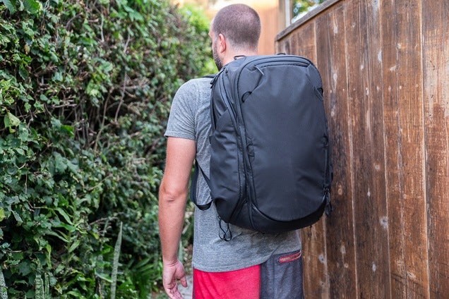 A tester from behind, wearing the uniformly black, sporty Peak Design bag