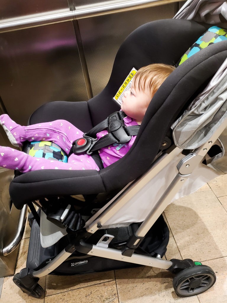 baby in cosco scenera next car seat in uppababy minu stroller, side angle