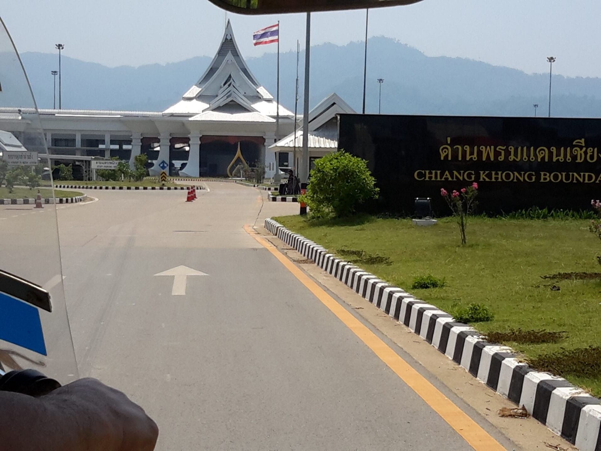 Chiang Khong Border checkpoint in Chiang Khong, Thailand with prominent signage and a distinctive white architectural structure in the background.