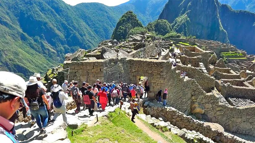 Warning sign indicating not to visit Machu Picchu on Sundays due to crowds