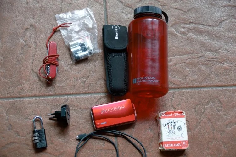 Technology items for travel, including a camera, power bank, and adapter, essential summer gear for travel Patagonia