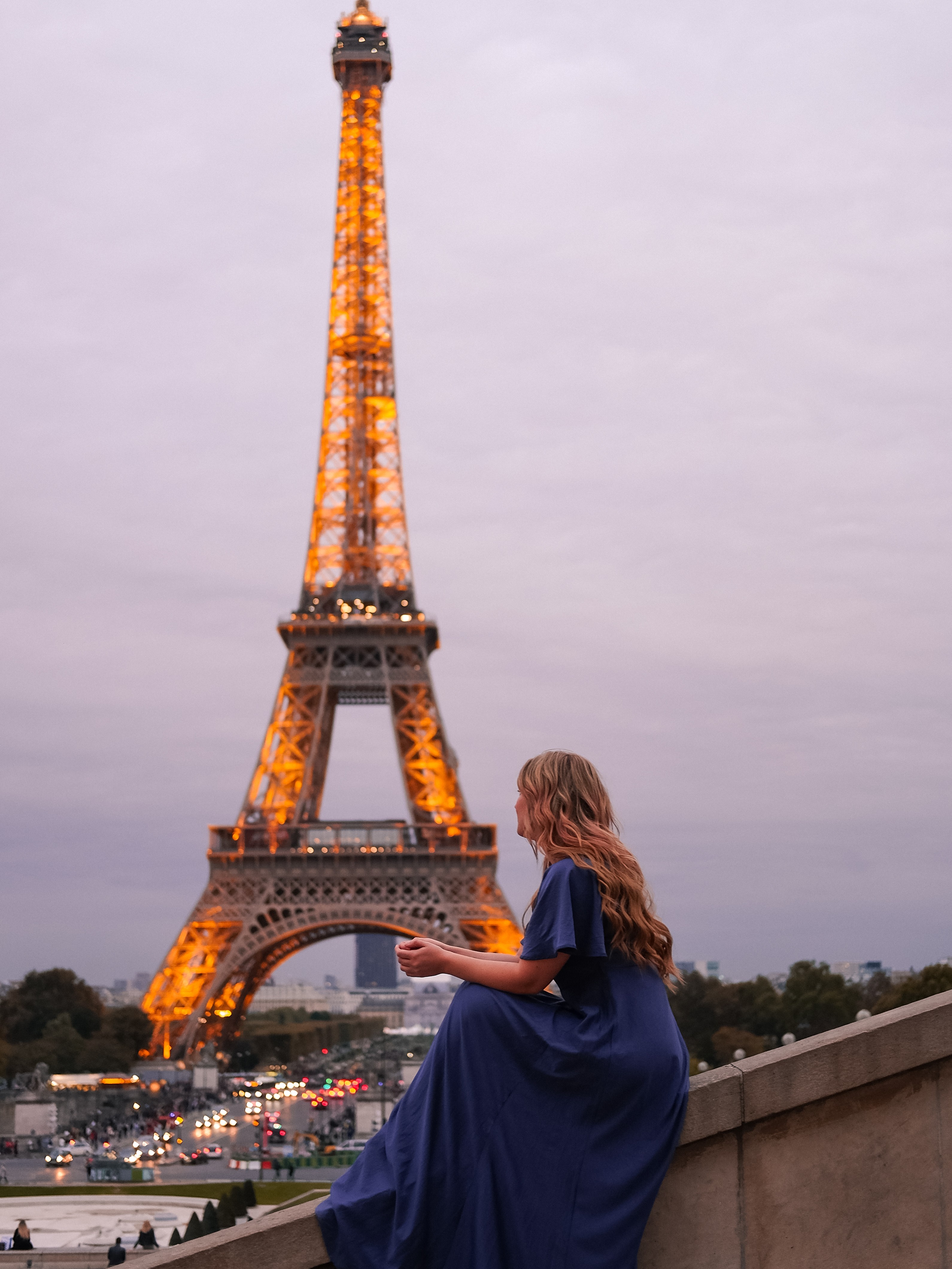 A photographer captures a woman in front of Parisian architecture during an Airbnb Experience photo tour, demonstrating photo-focused travel activities