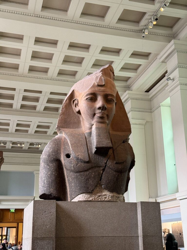 Egyptian artifacts on display in the British Museum, including sarcophagi and ancient sculptures