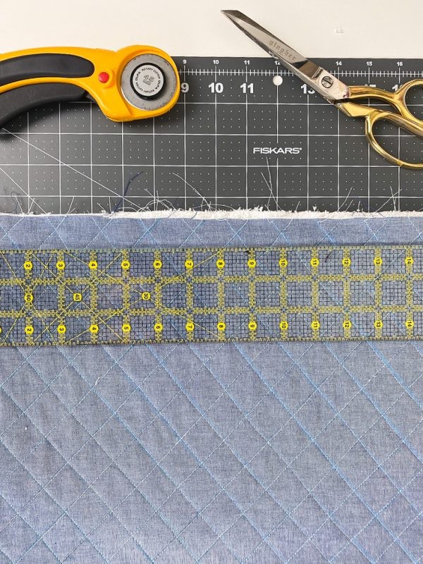 Trimming the edges of the changing pad with a rotary cutter and ruler.