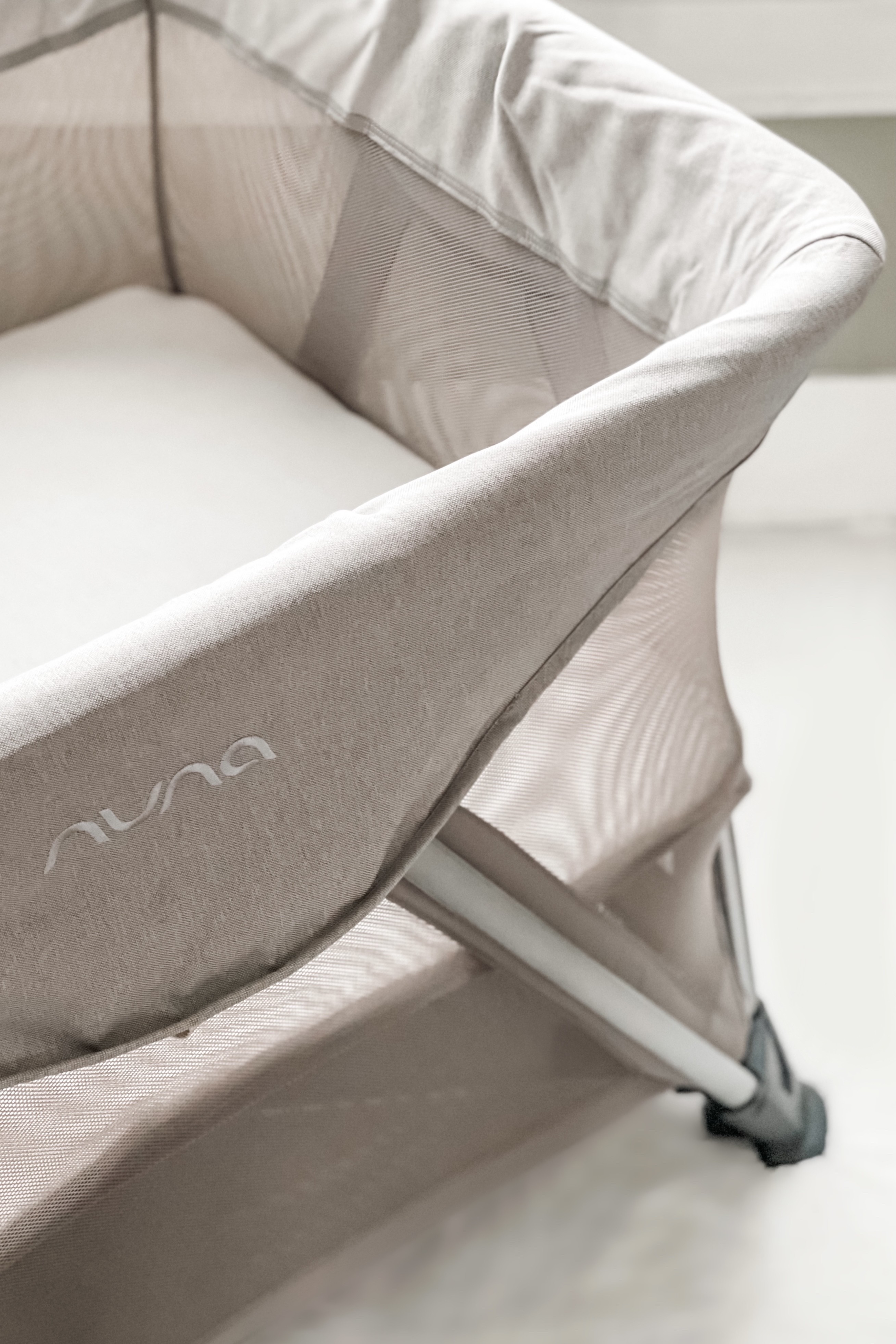 Nuna Sena Aire travel crib with bassinet insert, highlighting its portability and ease of use for travel.