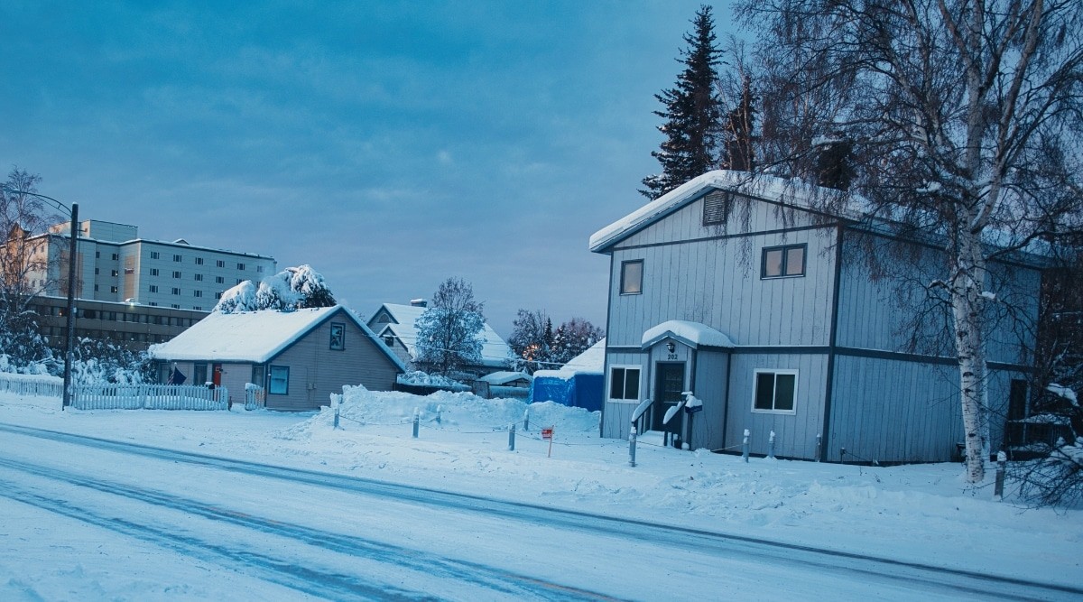 Evening view of a snow-covered city street in Fairbanks, Alaska, highlighting the winter landscape.