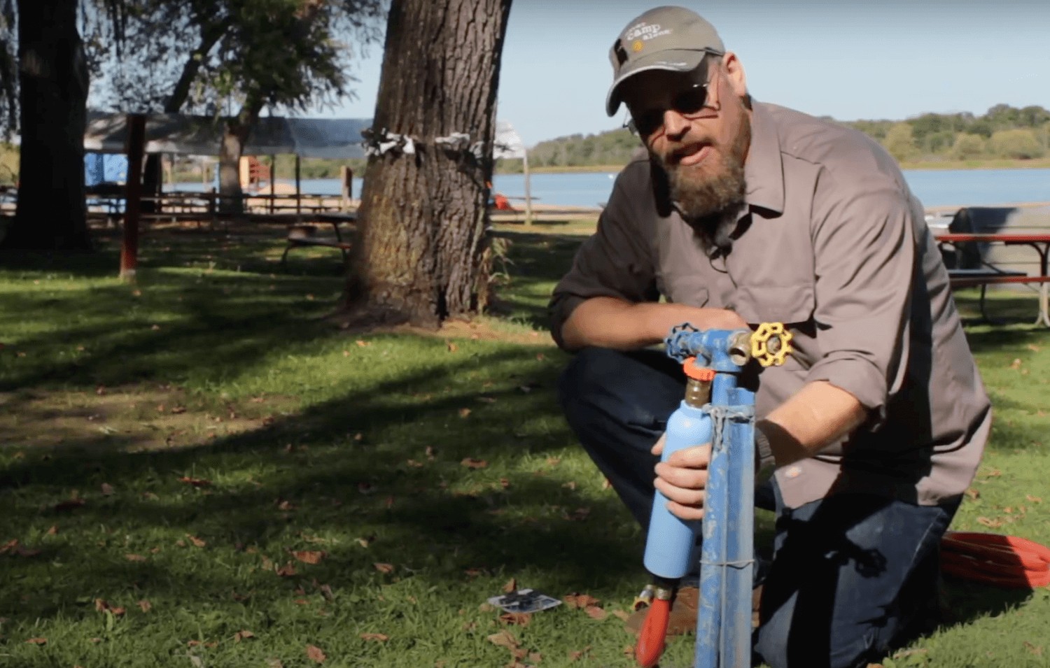 A brass travel trailer water pressure regulator connected to a water spigot, reducing pressure before water enters the RV plumbing system