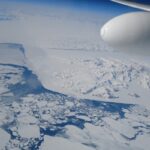 Aerial view of the vast, icy landscape of Antarctica from a plane window