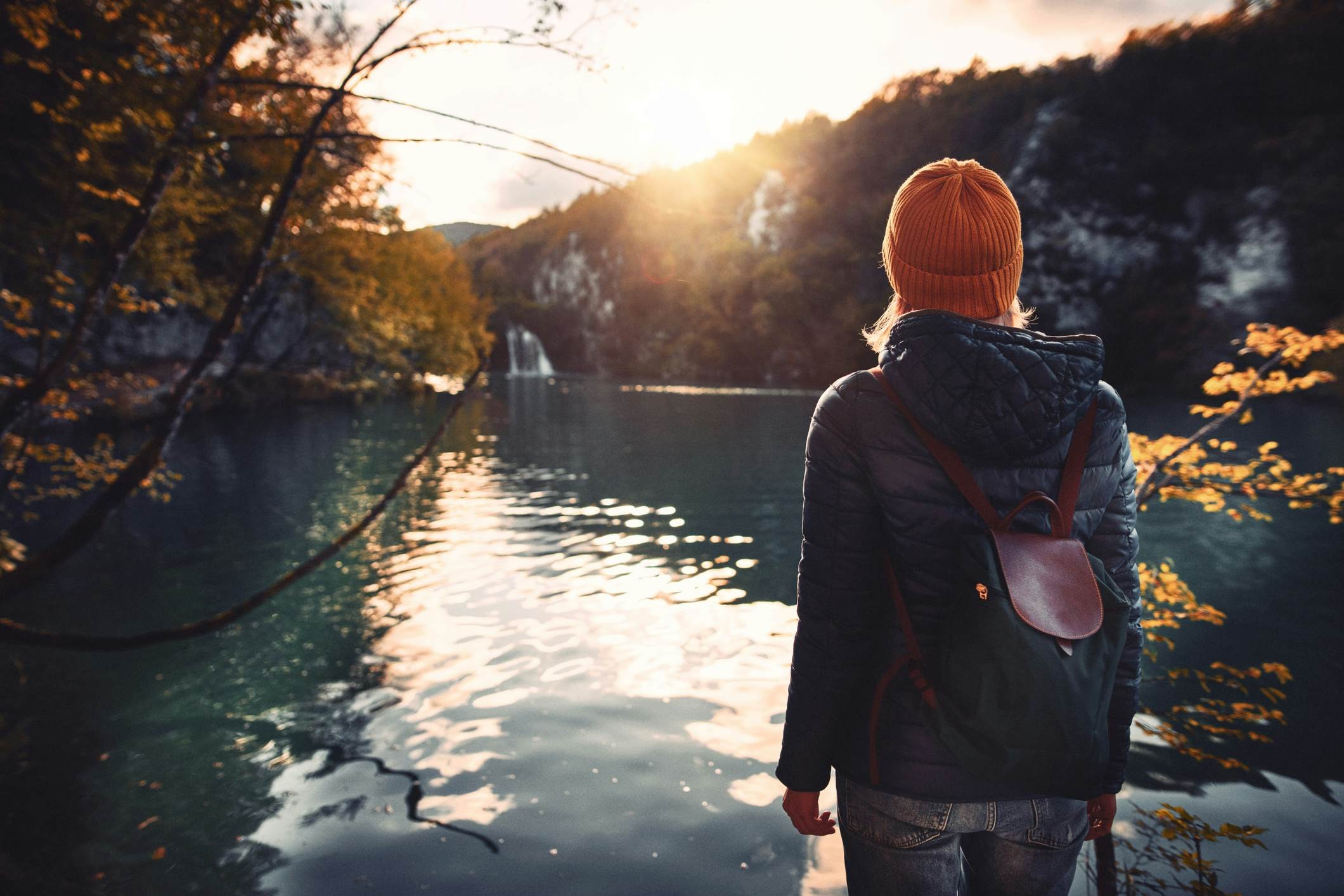 Woman tourist exploring Plitvice Lakes National Park at sunny autumn day in Croatia