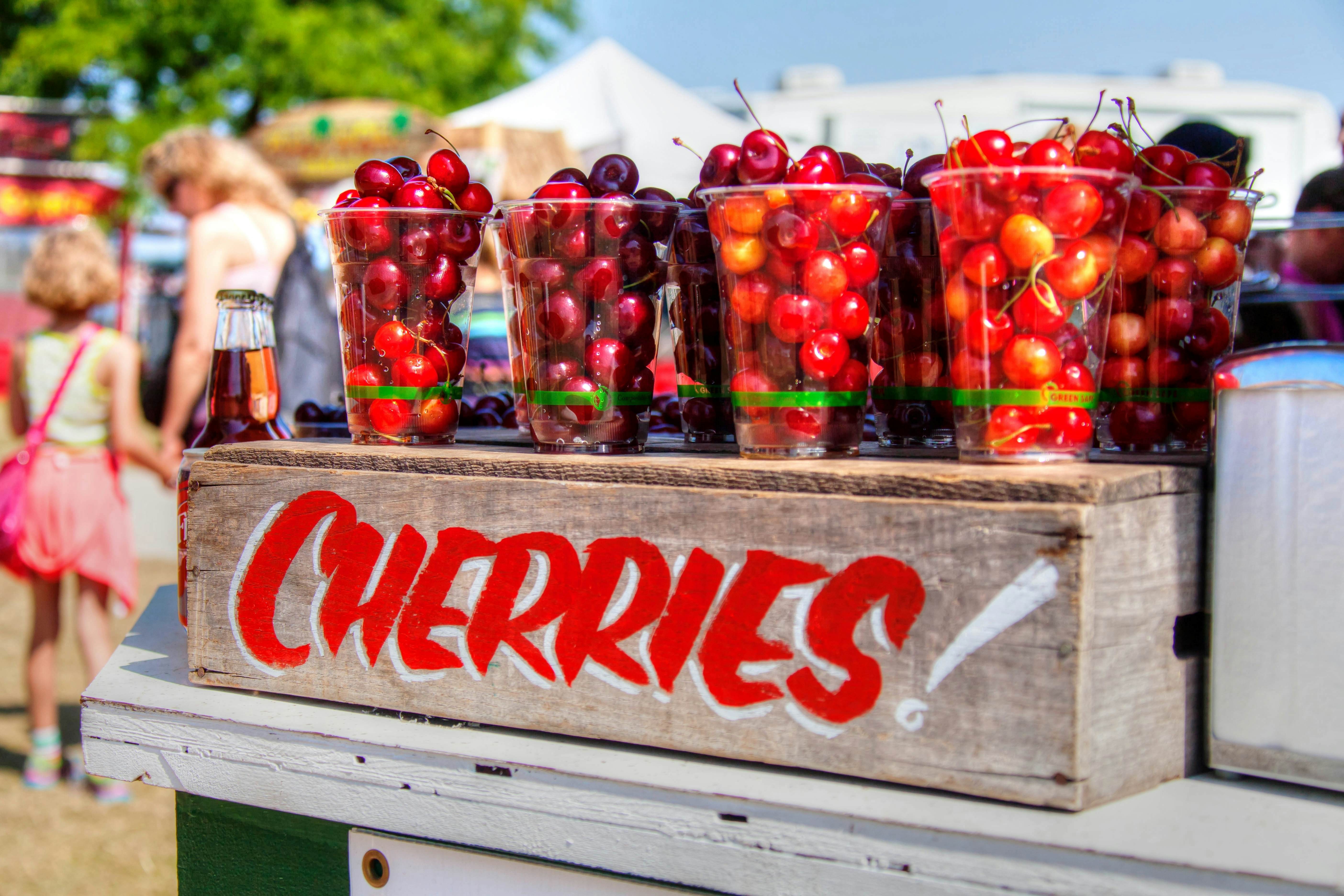 A vibrant cherry stand in Traverse City, Michigan, displaying the region's famous cherries and highlighting the agricultural bounty of the Midwest