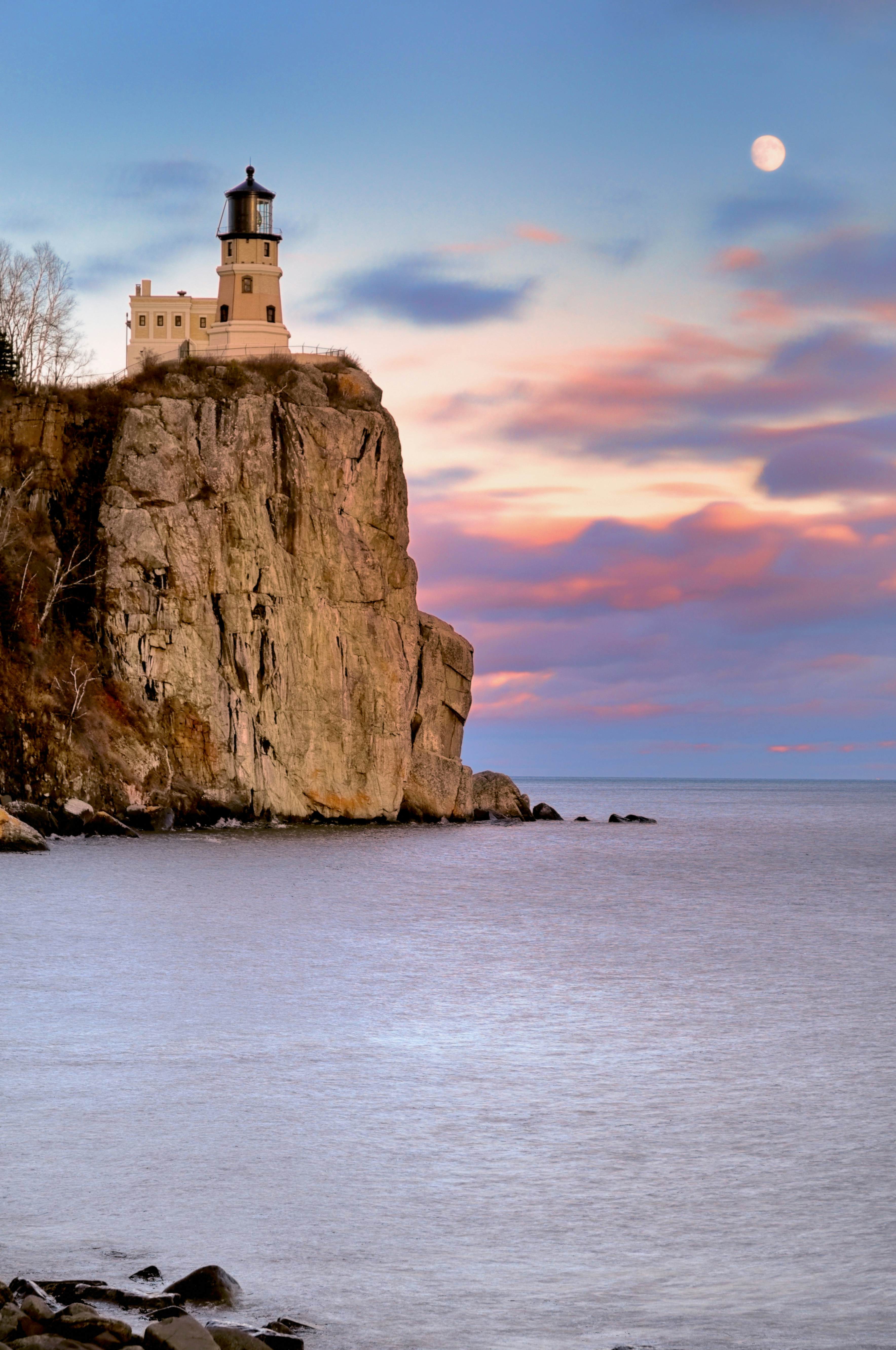 Split Rock Lighthouse illuminated at twilight along the rocky shores of Lake Superior, representing the scenic beauty of Minnesota's North Shore