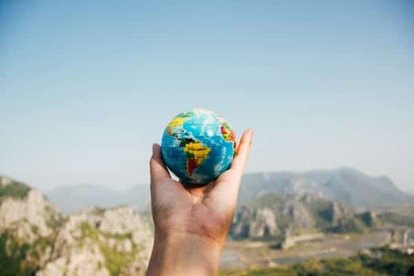 Someone holding a globe, representing travel and safe journey wishes