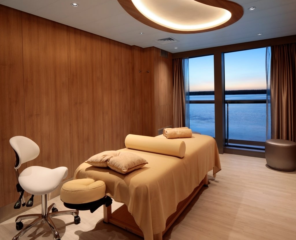 Relaxing spa bed with ocean view, offering acupuncture treatments for cruise travel sickness relief onboard a cruise ship.