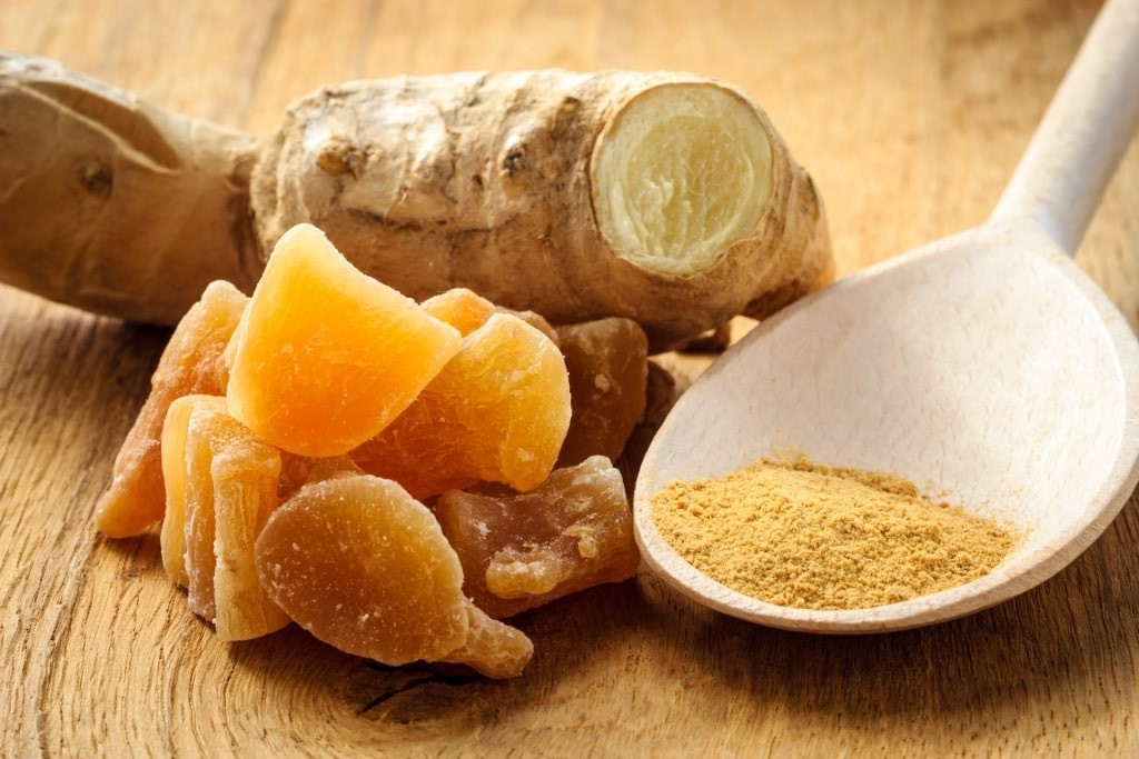 Natural remedies for cruise travel sickness including ginger candies, powdered ginger, and ginger root.