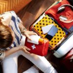 Woman packing seasickness medication and a first aid kit for a cruise to prevent cruise travel sickness.