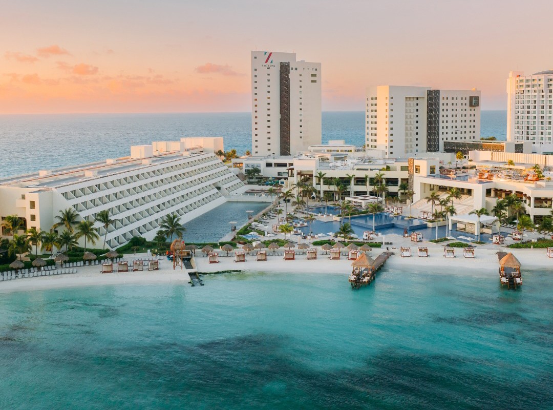 Hyatt Cancun resort in Mexico showcasing travel agent rates benefits with palm trees and beach view.