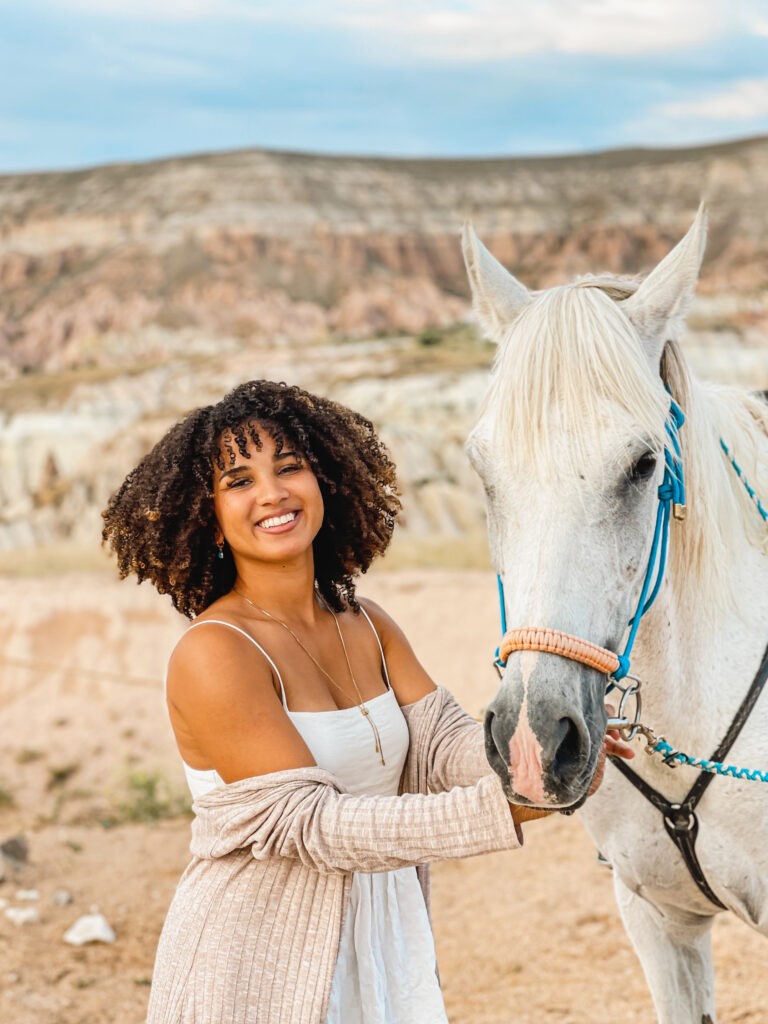 Woman with curly hair in Cappadocia, Turkey, showcasing natural travel hair