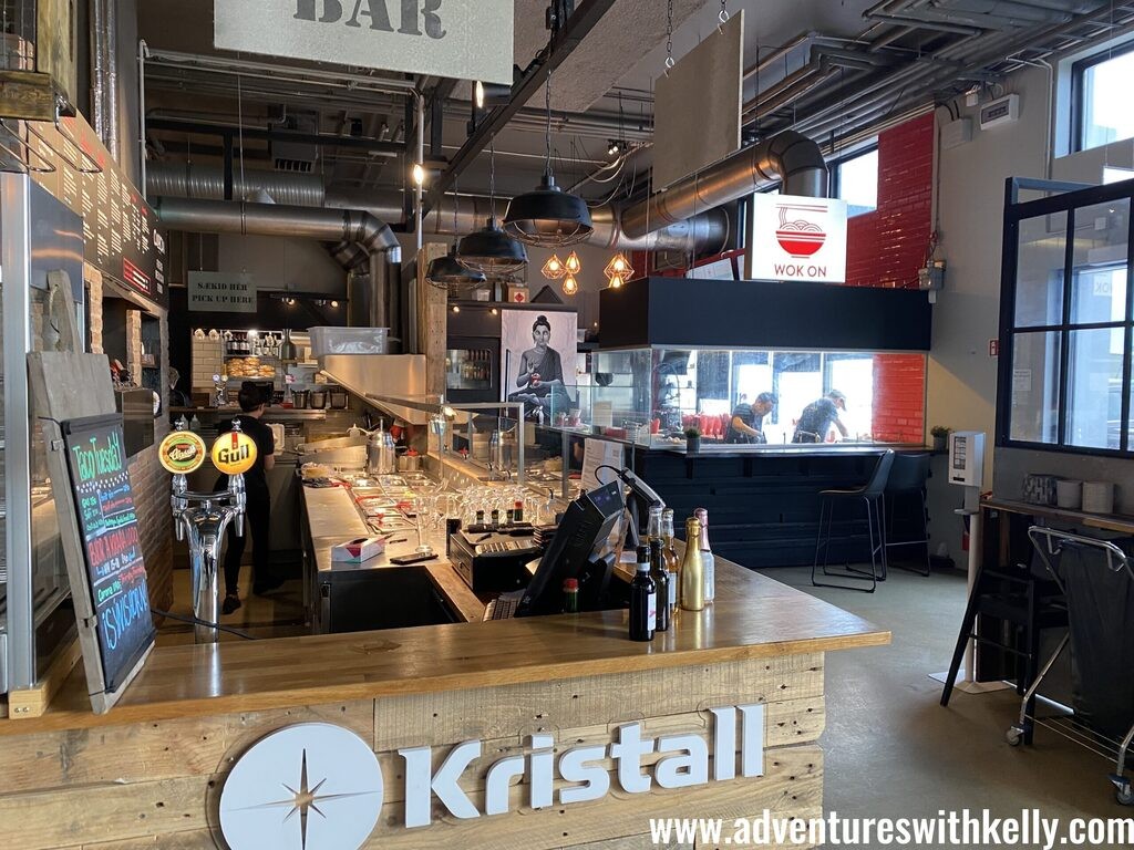 Exploring diverse food stalls at Mathöll Höfða food hall in Reykjavik.