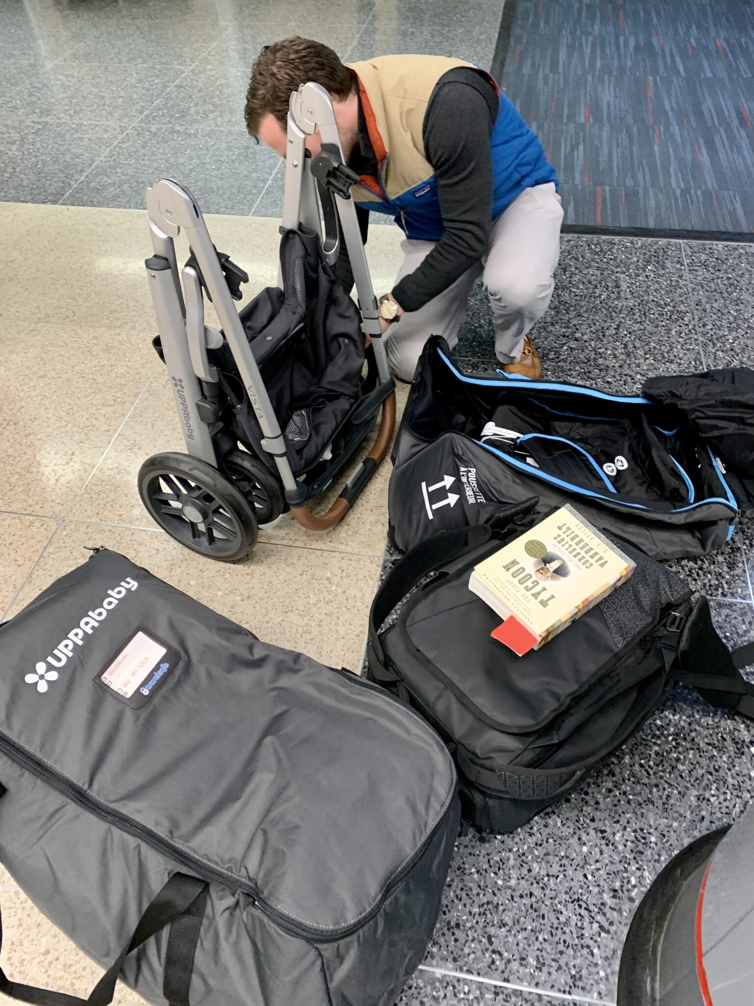 Father folding UPPAbaby Vista stroller at airport security