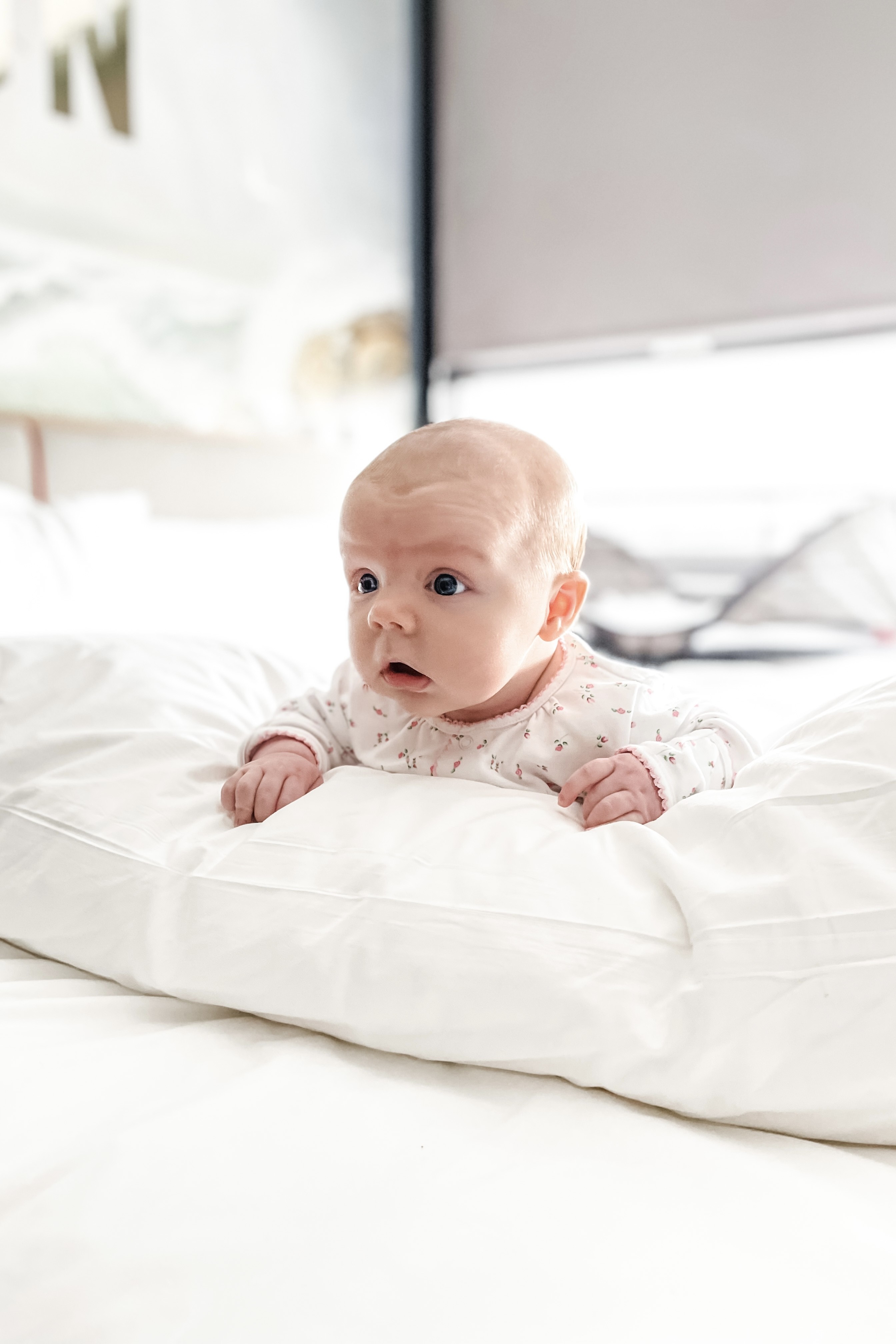 Baby doing tummy time in a hotel room, illustrating how to maintain baby's routine while traveling.