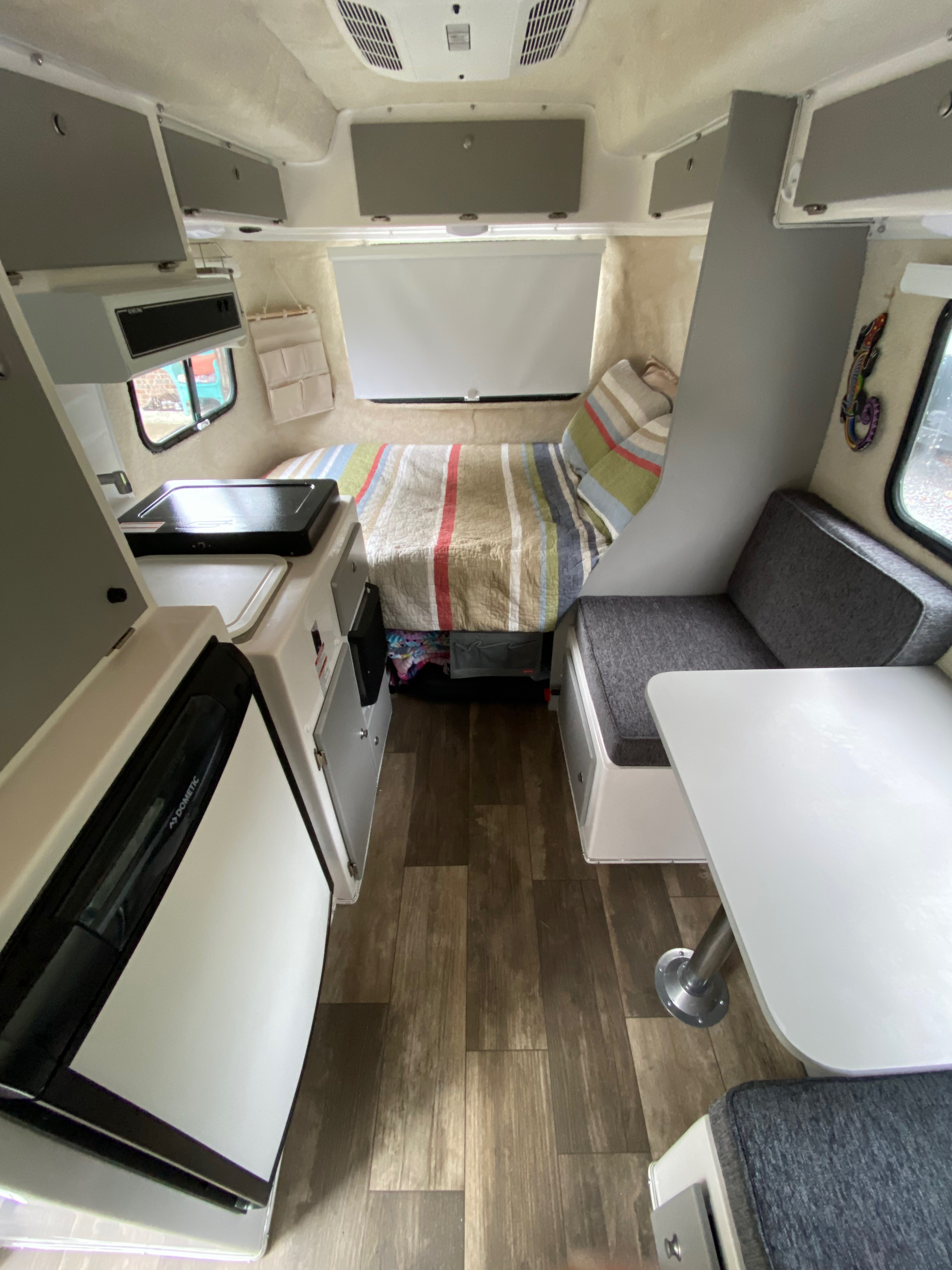 Exterior view of a Casita travel trailer parked in a campsite, showcasing its compact size and fiberglass shell.