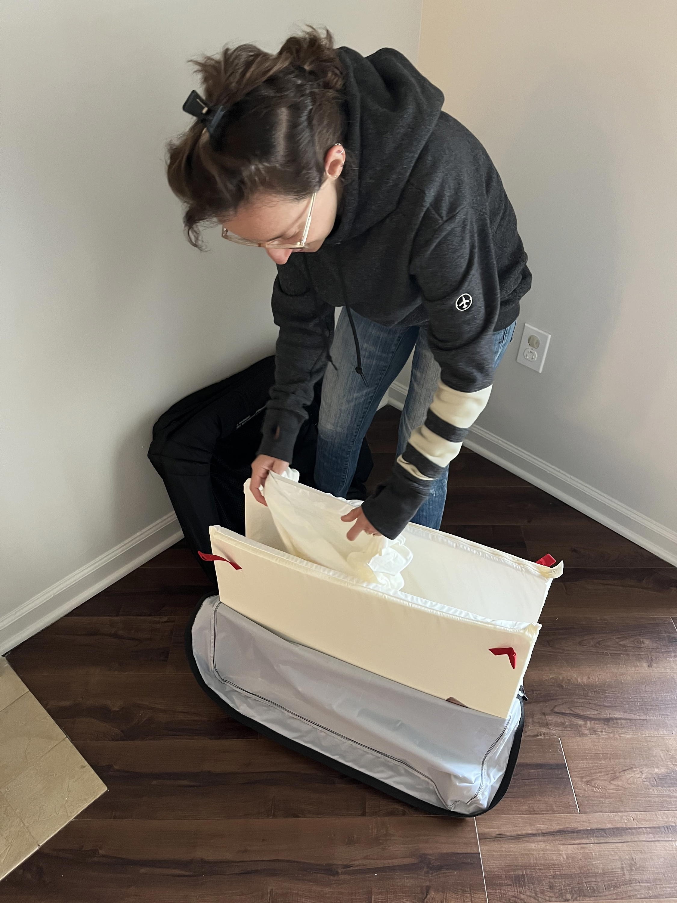 Women setting up the Baby Bjorn Travel Crib