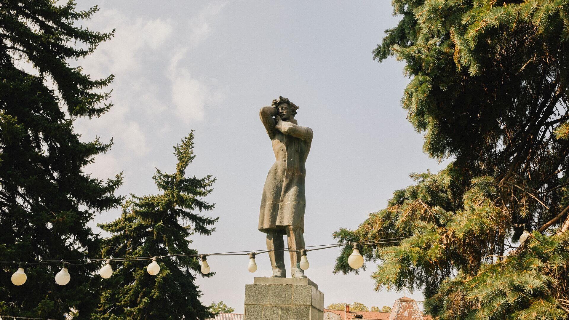 A statue of Joseph Stalin in Gori, surrounded by trees, a somber reminder of the Soviet leader's birthplace.