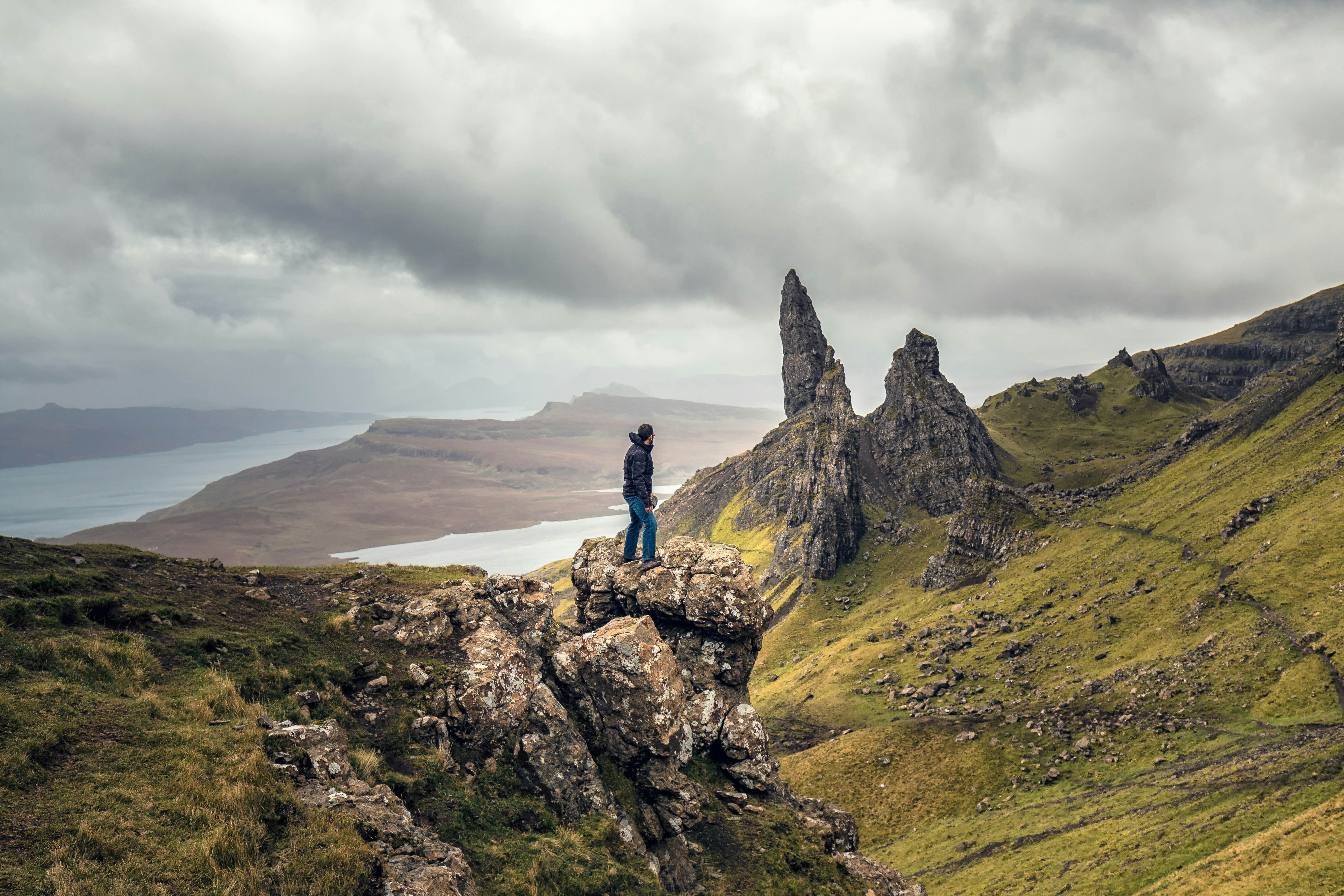 Man overlooking view Old Man of Storr in Autumn on the Isle of Skye, Scotland, UK