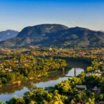 Sunset paints the sky over Luang Prabang, Laos, where the Mekong and Nam Khan rivers meet, showcasing the serene beauty of this Southeast Asian gem